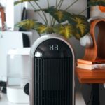 A black and white air purifier sitting on top of a wooden table
